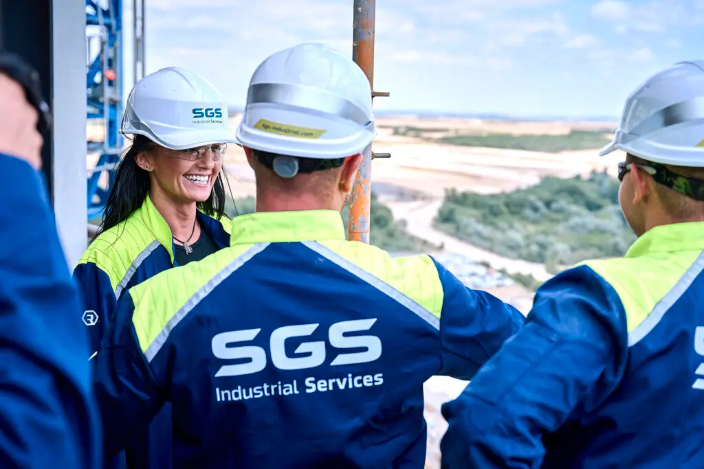 MitarbeiterInnen von SGS Industrial Services in individuell gestalteter Berufsbekleidung mit eigenem Design, Unternehmensfarben und Logo.